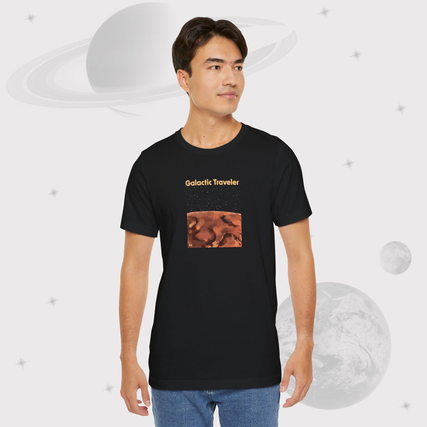 Guy wearing Going Across men's basic t-shirt in black, featuring the text ‘Galactic Traveler’ and space art of a red planet and a starry sky by Manharleen.