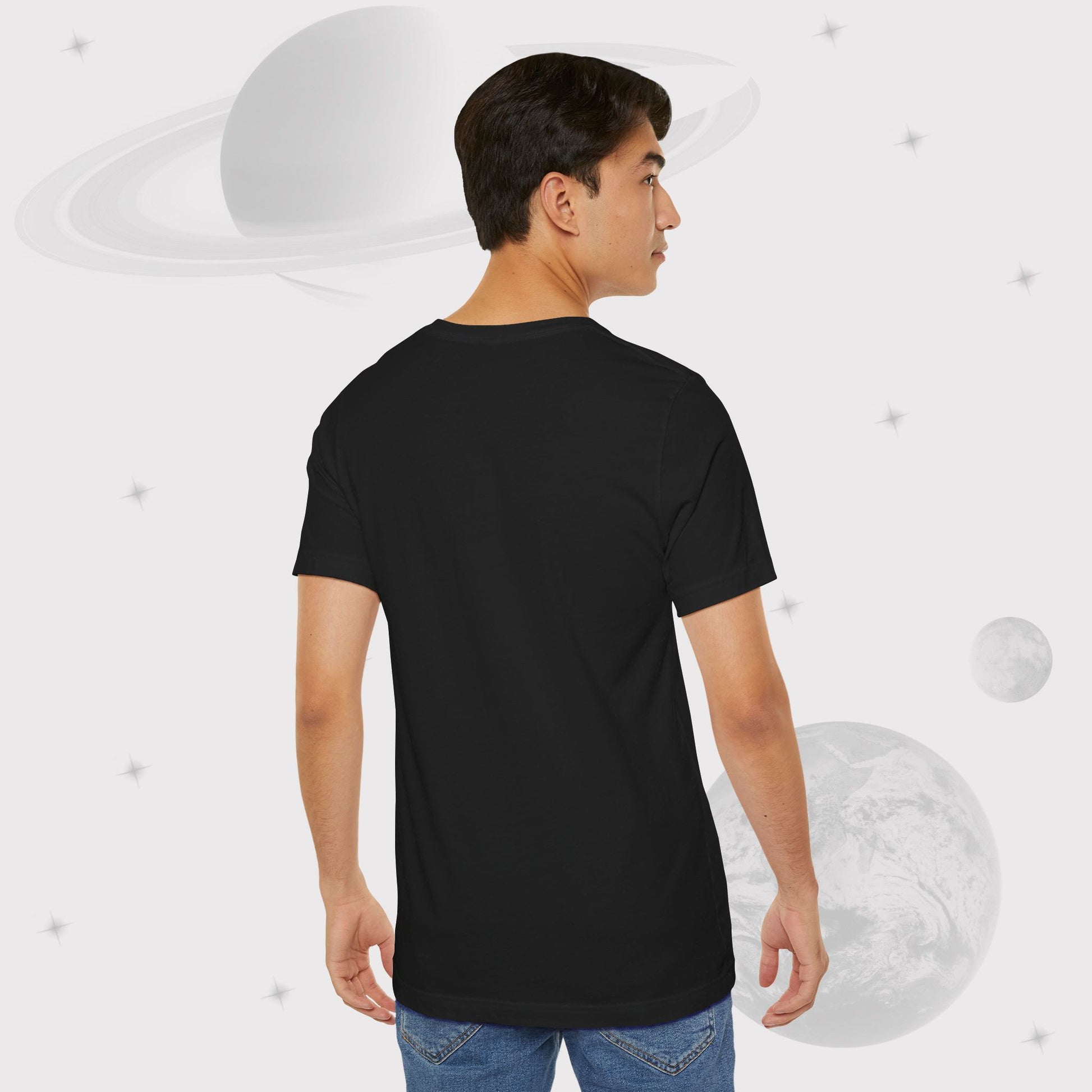 Back side of guy wearing Going Across men's basic t-shirt in black, with jeans, featuring the text ‘Stellar Frontier’ and vibrant yellow, deep blue space art by Manharleen.