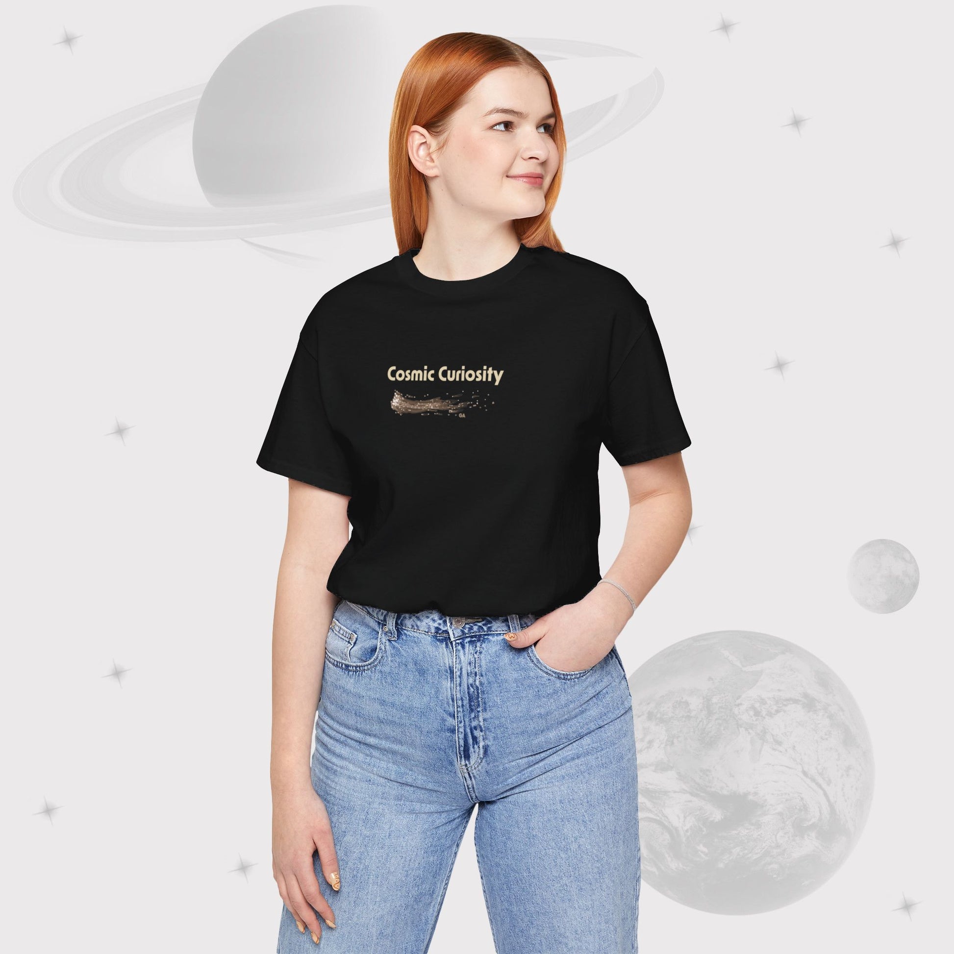 Woman wearing Going Across women's basic t-shirt in black with high waist jeans, featuring the text ‘Cosmic Curiosity’ with space art of shooting stars by Manharleen.