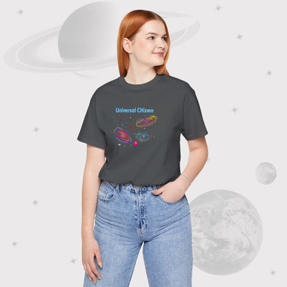 Woman wearing Going Across women's basic t-shirt in asphalt/gray with high waist jeans, featuring the text ‘Universal Citizen’ with space art of vibrant galaxies and planets by Manharleen.