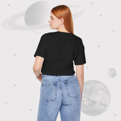 Back side of a Woman wearing Going Across women's basic t-shirt in black with high waisted jeans, featuring the text ‘Galactic Traveler’ with space art of a red planet and a starry sky by Manharleen.