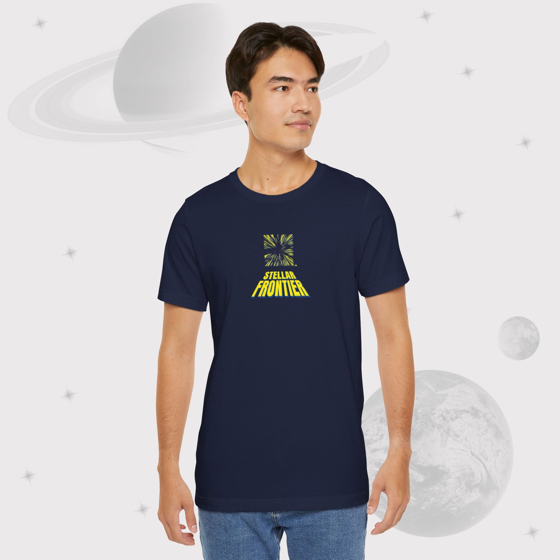 Guy wearing Going Across men's basic t-shirt in navy, with jeans, featuring the text ‘Stellar Frontier’ and vibrant yellow, deep blue space art by Manharleen.