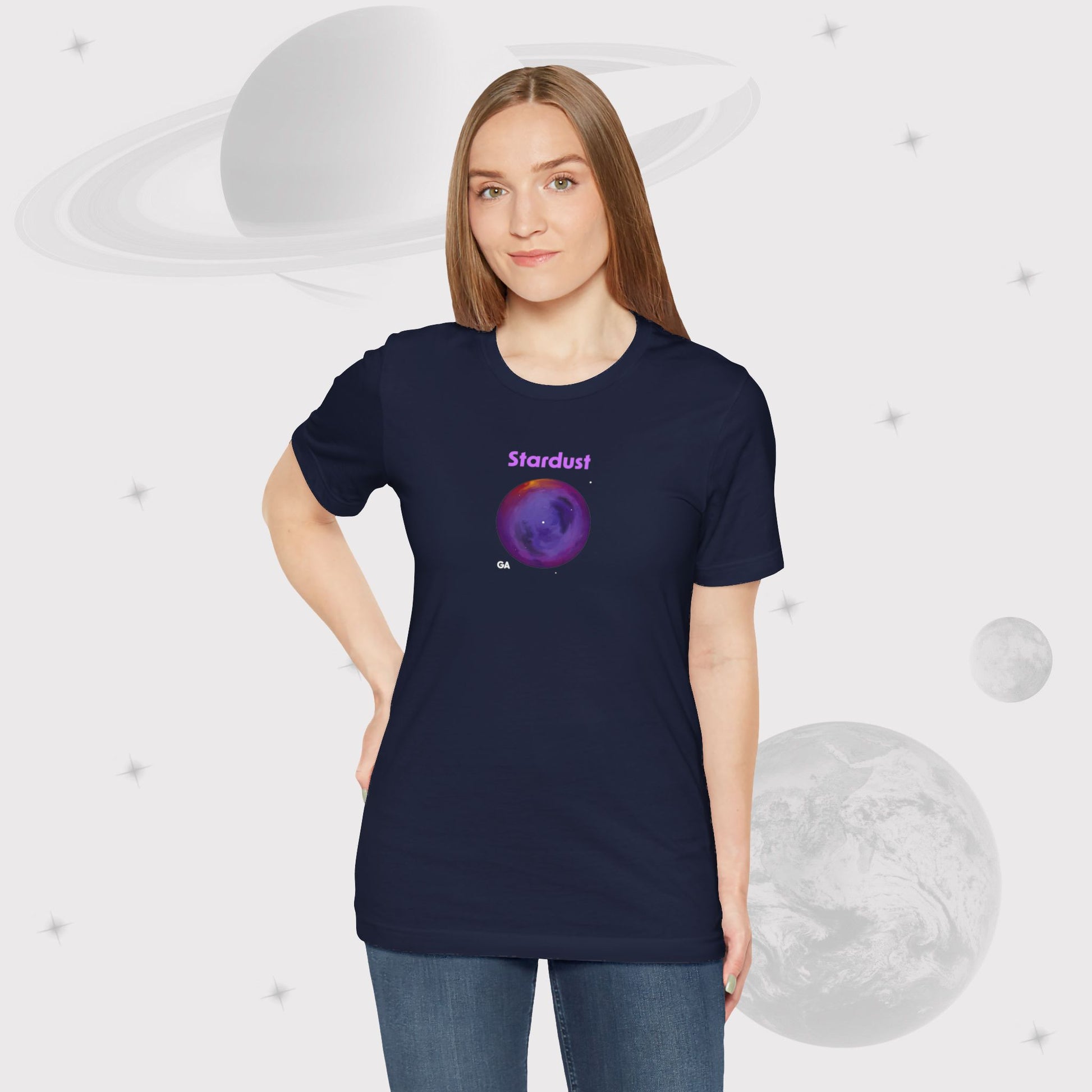 Woman wearing Going Across women's basic t-shirt in navy with pants, featuring the text ‘Stardust’ with space art of bright purple nebula by Manharleen.