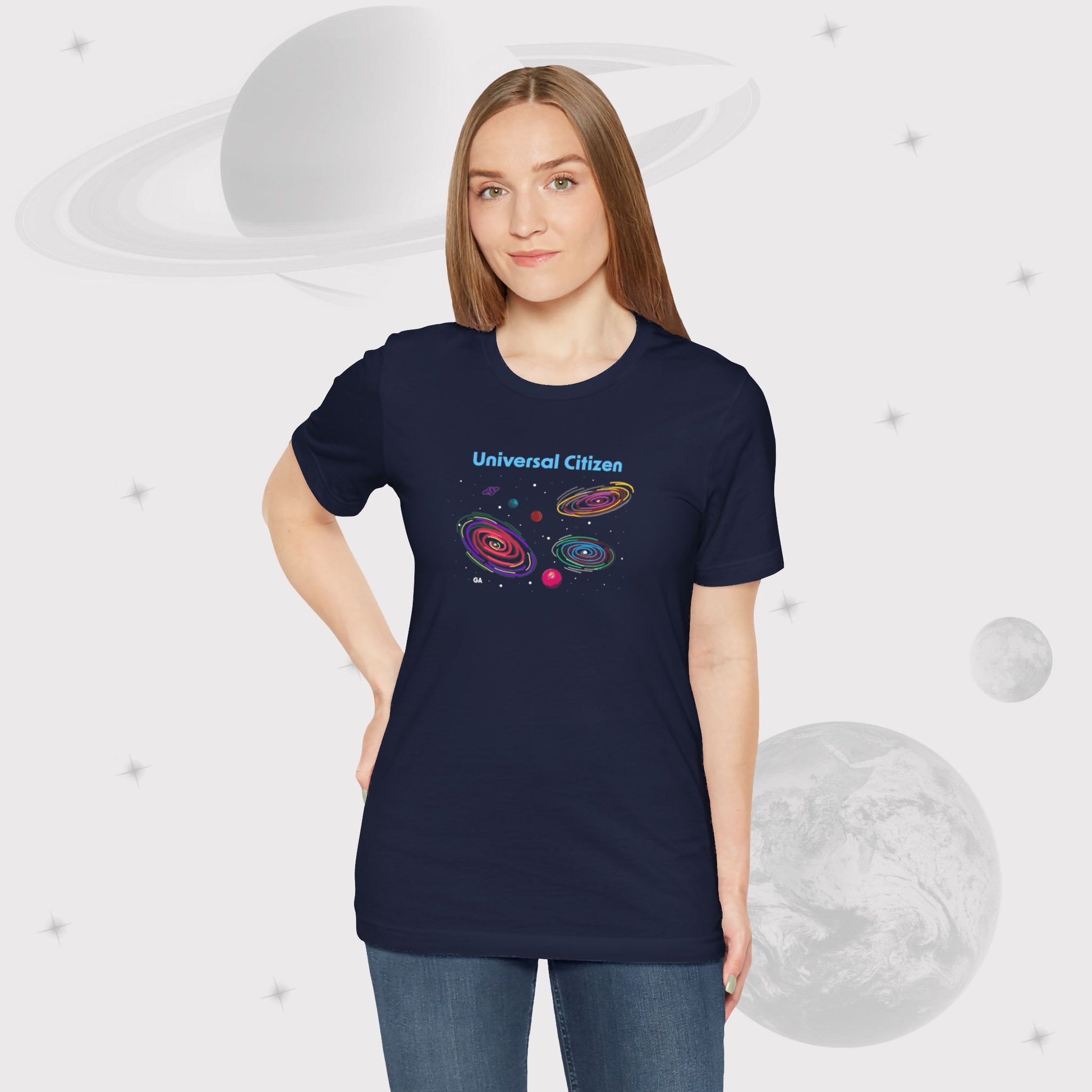 Woman wearing Going Across women's basic t-shirt in navy with dark blue jeans, featuring the text ‘Universal Citizen’ with space art of vibrant galaxies and planets by Manharleen.