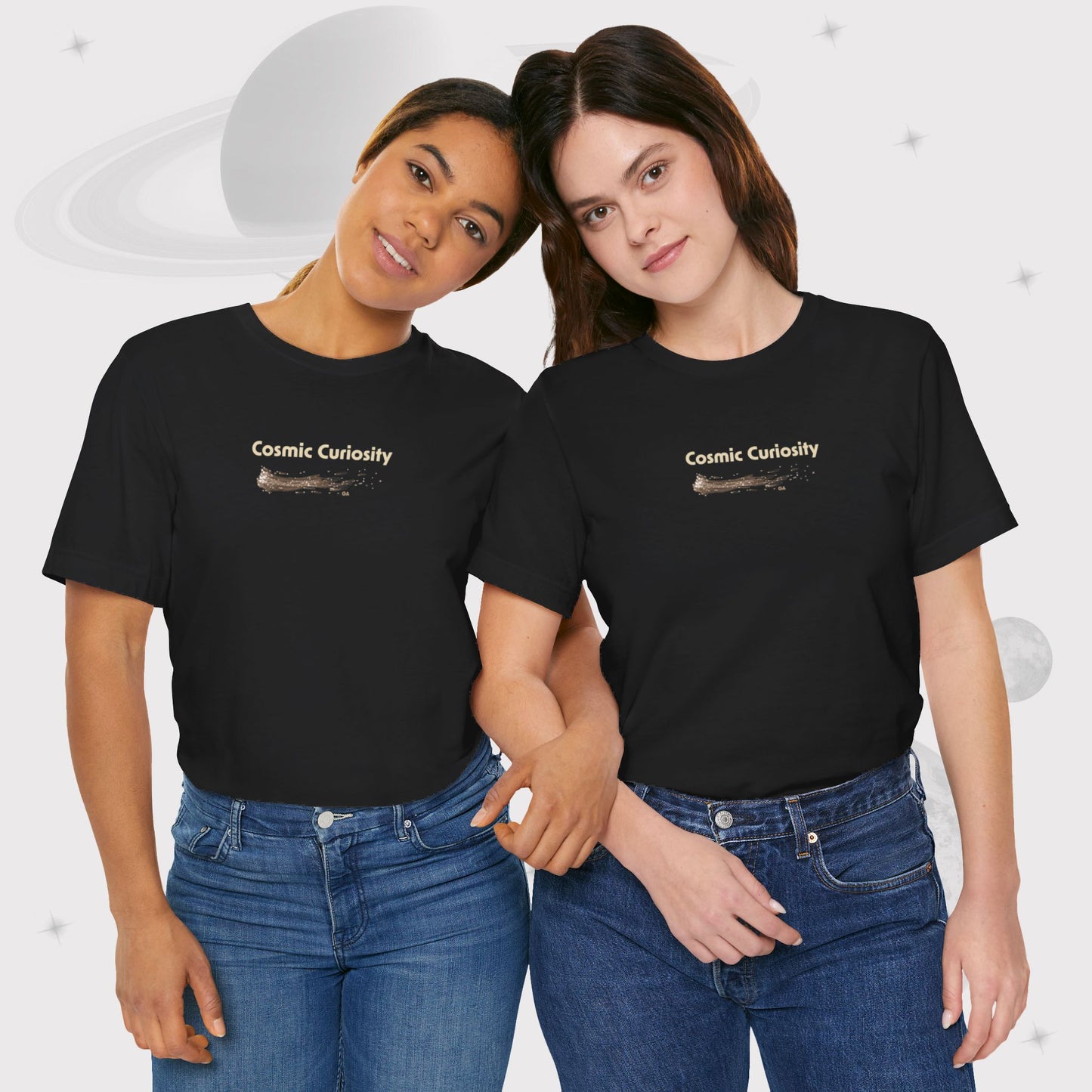 Two women wearing Going Across women's basic t-shirt in black, featuring the text ‘Cosmic Curiosity’ with space art of shooting stars by Manharleen.