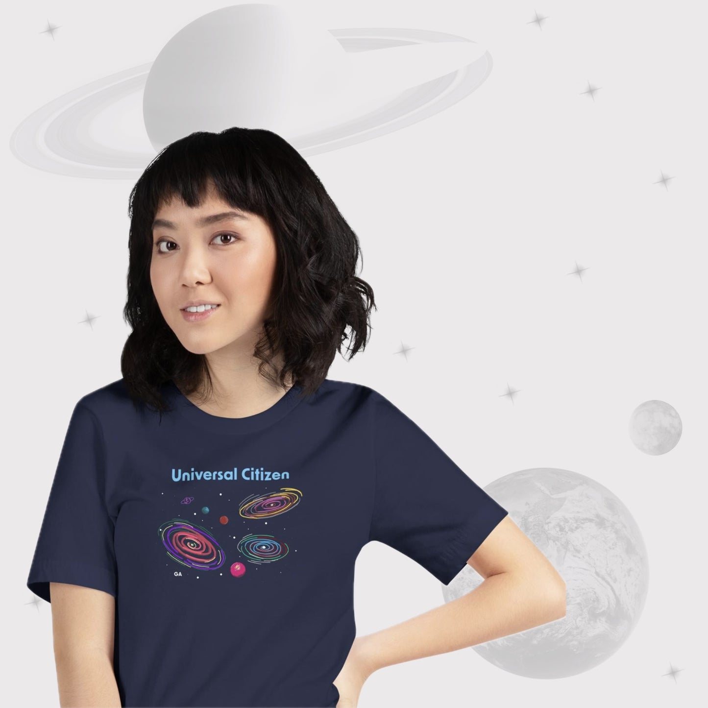 Woman wearing Going Across women's basic t-shirt in navy, featuring the text ‘Universal Citizen’ with space art of vibrant galaxies and planets by Manharleen.