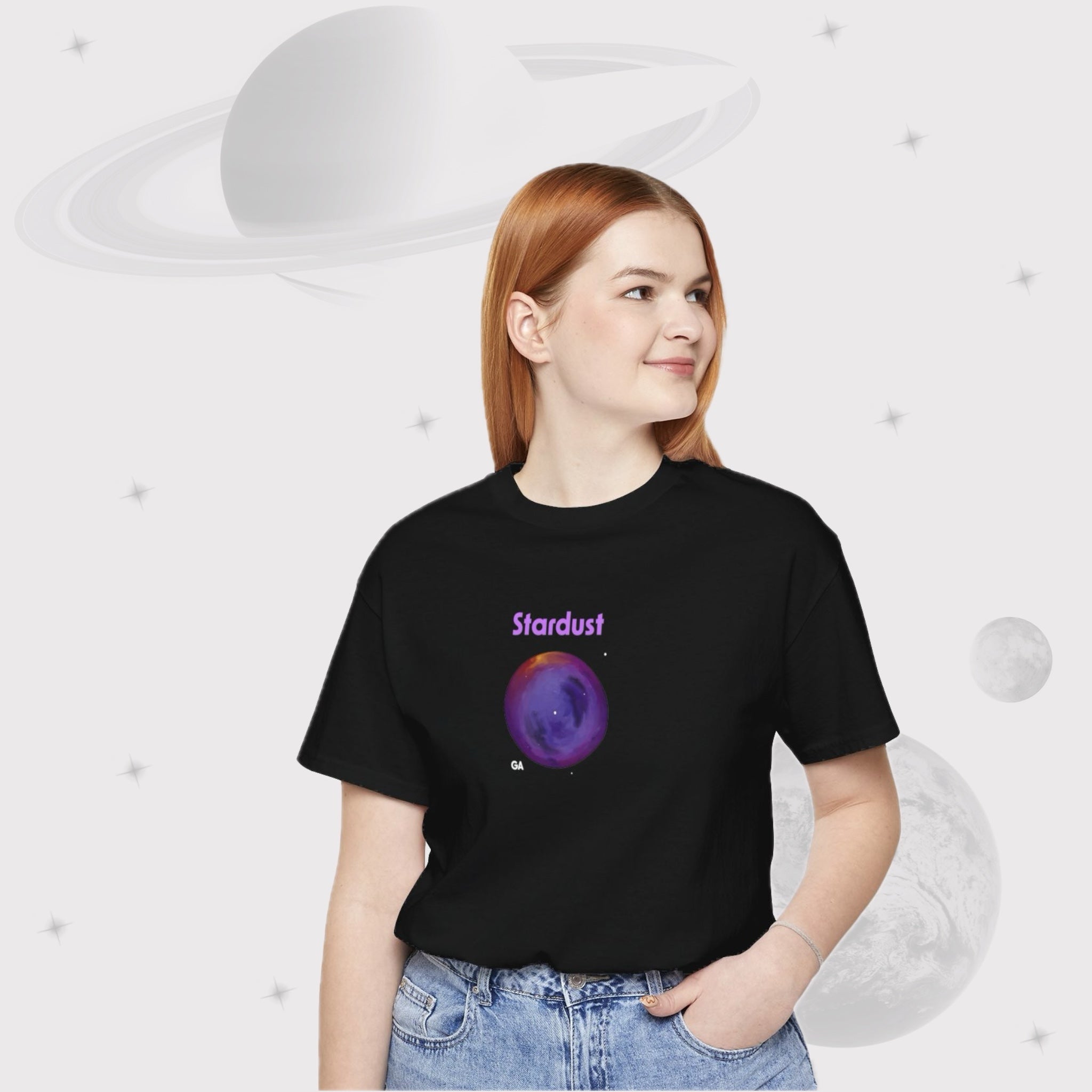 Woman wearing Going Across women's basic t-shirt in black, featuring the text ‘Stardust’ with space art of bright purple nebula by Manharleen.