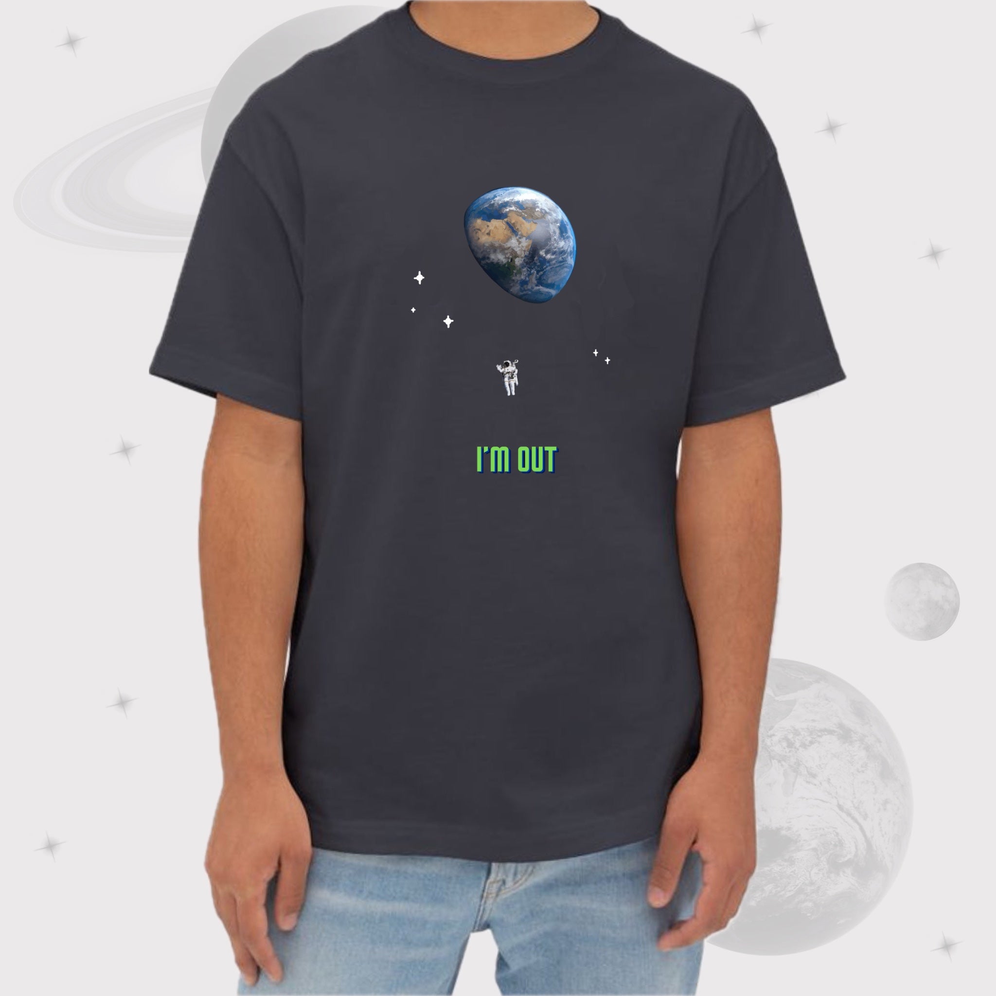 Man wearing Going Across men's oversized boxy t-shirt in dark grey, featuring the text ‘I'M OUT’ with space art of an astronaut and earth by Manharleen.