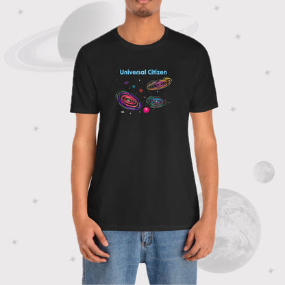 Man wearing Going Across men's basic t-shirt in black, wearing jeans, featuring the text ‘Universal Citizen’ with space art of vibrant galaxies and planets.