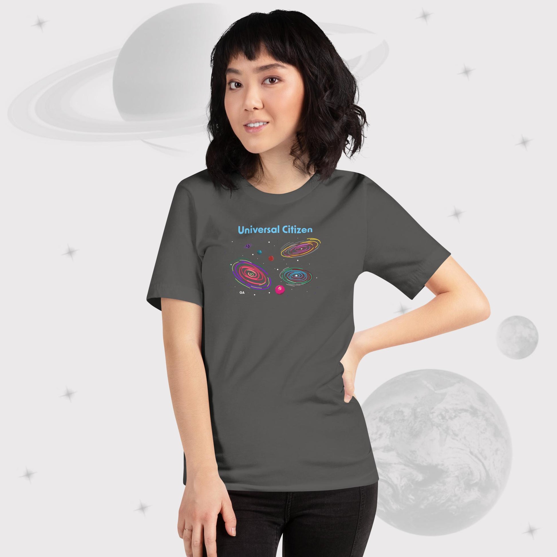 Woman wearing Going Across women's basic t-shirt in asphalt/gray with leggings, featuring the text ‘Universal Citizen’ with space art of vibrant galaxies and planets by Manharleen.