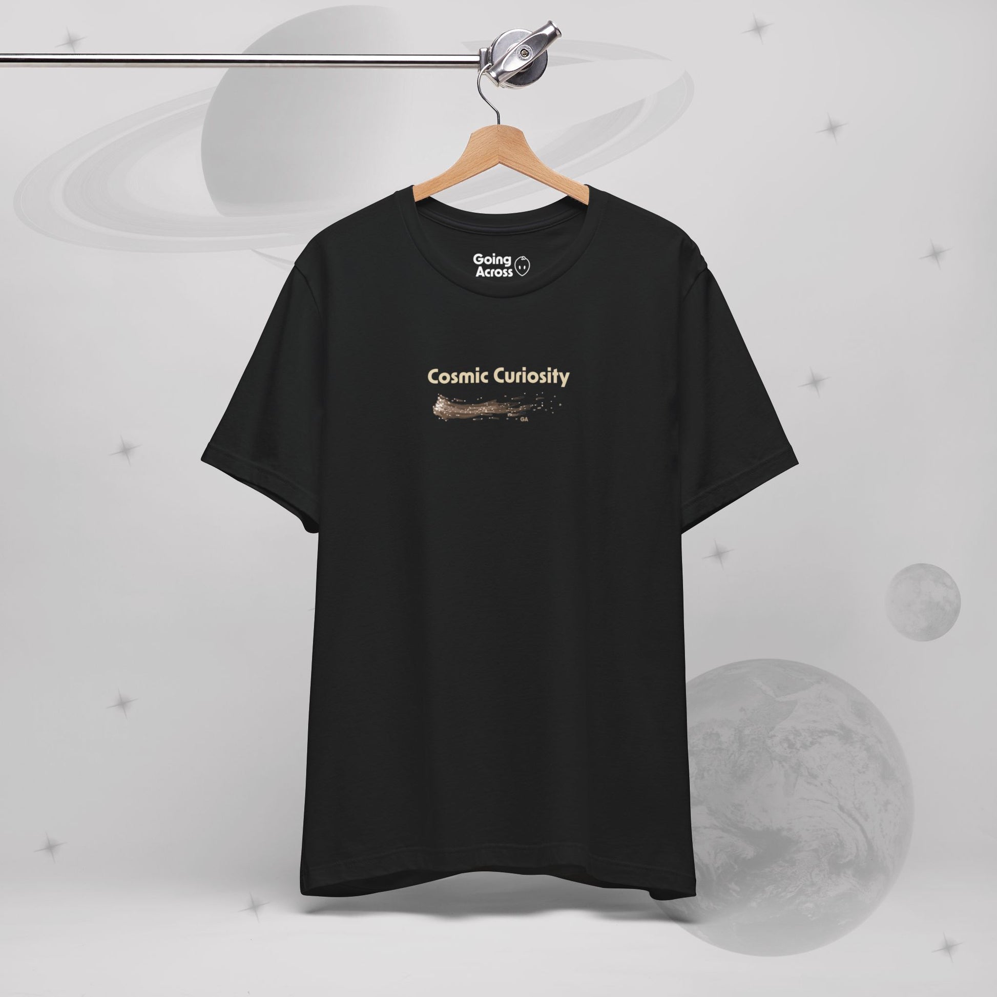 Going Across men's basic t-shirt in black, hanging, featuring the text ‘Cosmic Curiosity’ with space art of shooting stars by Manharleen.